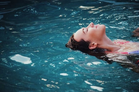 Frau schwimmt in einem Schwimmbecken