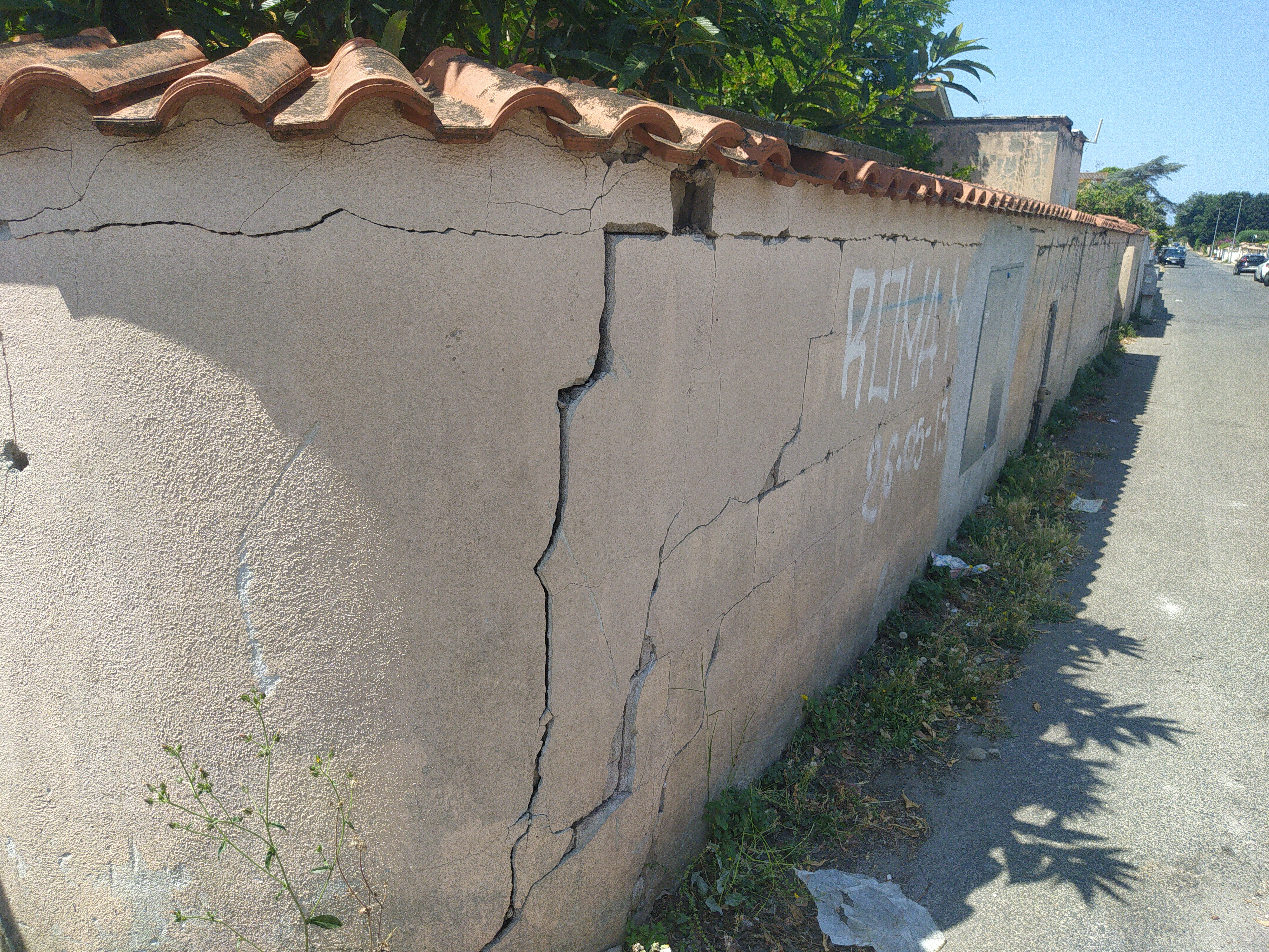 Außenmauer eines Grundstücks mit starken Rissen