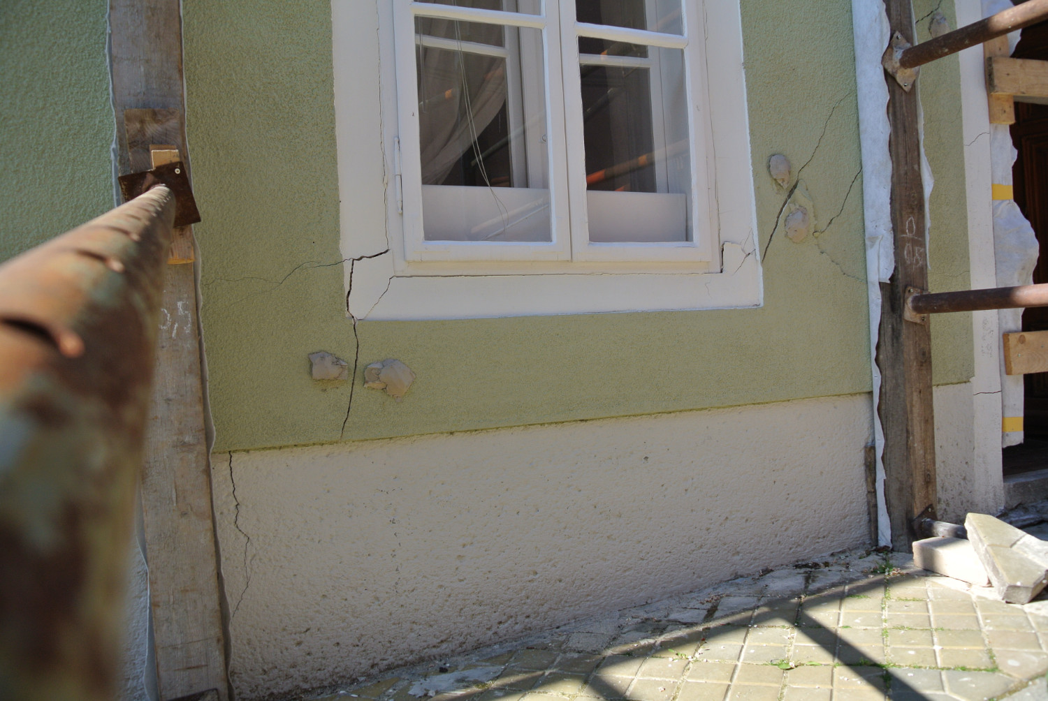 Sichtbare Setzungsrisse an Mauer und Fenstern